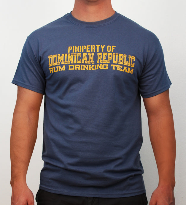 Indigo blue t-shirt with yellow text ‘Property of Dominican Republic Rum Drinking Team’ on a plain background by Hot Penguin, Ltd.